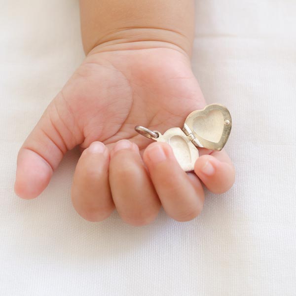 baby holding locket